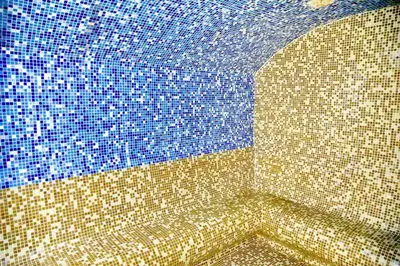 a bathroom with a tiled wall with a blue at Kophill L36 Milmari in Kopaonik