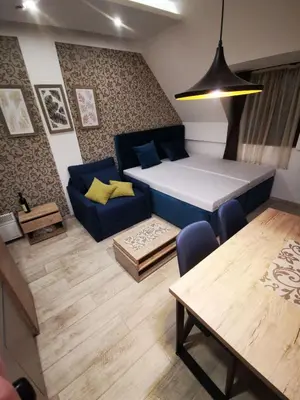 a living room with a blue couch and a table at Kopaonik Apartman Squadra in Kopaonik