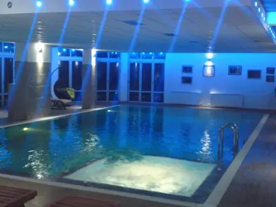 a large swimming pool in a building with blue lights at Kopaonik Apartman Squadra in Kopaonik