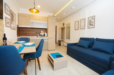 a living room with a blue couch and a table at Kopaonik Apartman Squadra in Kopaonik