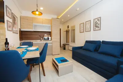 a living room with a blue couch and a table at Kopaonik Apartman Squadra in Kopaonik