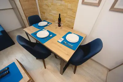 a wooden table with chairs and a bottle of wine at Kopaonik Apartman Squadra in Kopaonik