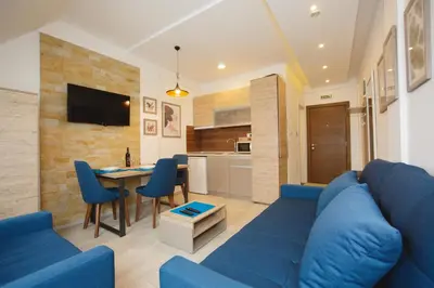 a living room with a blue couch and a table at Kopaonik Apartman Squadra in Kopaonik