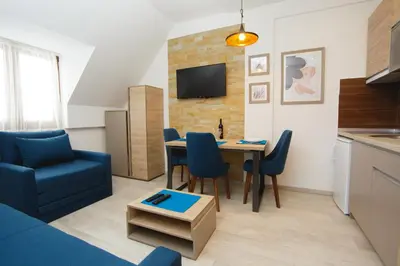 a living room with a blue couch and a table at Kopaonik Apartman Squadra in Kopaonik