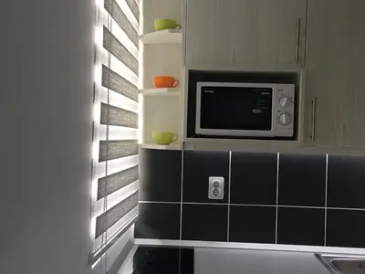 a kitchen with a microwave on a wall at Apartment Ramonda in Kopaonik