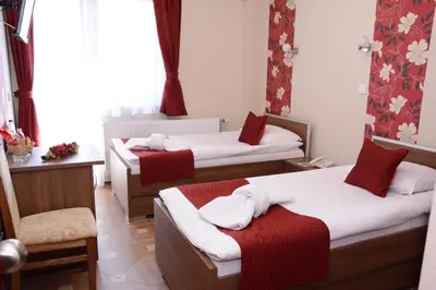 a room with two beds with red and white towels at Garni Hotel Laguna Lux in Niš