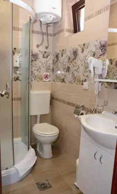 a bathroom with a toilet and a sink and a shower at Garni Hotel Laguna Lux in Niš