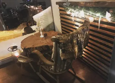 a wooden table with a rocking chair in a room at Villa Popara Kopaonik in Kopaonik