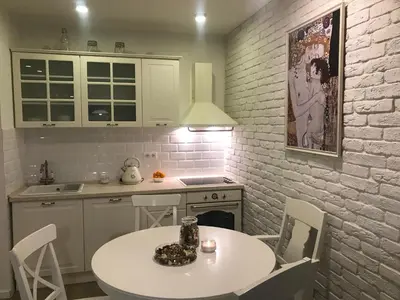 a kitchen with a white table and a white brick wall at PROMO Evergreen apartments in Kopaonik