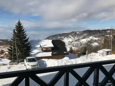 a white car parked in the snow on a balcony at PROMO Evergreen apartments in Kopaonik