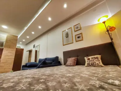 a bedroom with a large bed and a couch at Apartman Pahulja - Milmari in Kopaonik