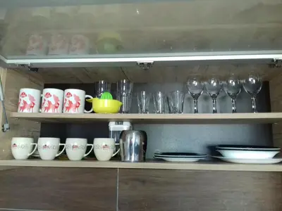 a shelf with cups and wine glasses on it at Apartman Pahulja - Milmari in Kopaonik