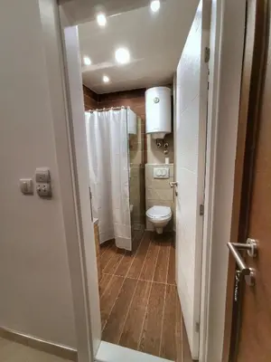 a small bathroom with a toilet and a shower at Apartman Pahulja - Milmari in Kopaonik