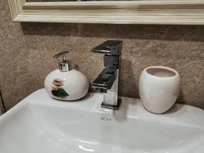 a bathroom sink with a faucet and a cup on it at Apartman Pahulja - Milmari in Kopaonik