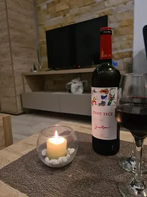 a bottle of wine and a candle and a glass at Apartman Pahulja - Milmari in Kopaonik