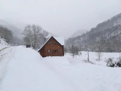 a wooden cabin in a snow covered field at Vila Jelena in Crni Vrh