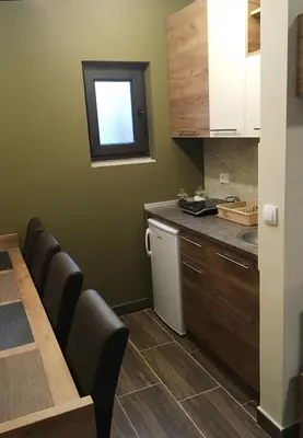 a small kitchen with a table and a sink at Villa Polaris in Kopaonik