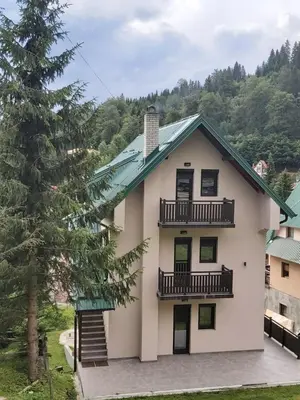 a house with two balconies and a tree at Villa Polaris in Kopaonik