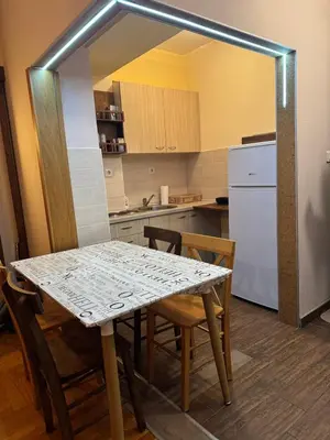 a kitchen with a table and chairs and a refrigerator at Suncani apartman 26 in Brzeće