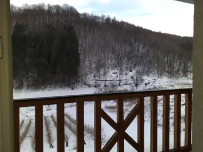 a view of a snow covered field from a balcony at Suncani apartman 26 in Brzeće
