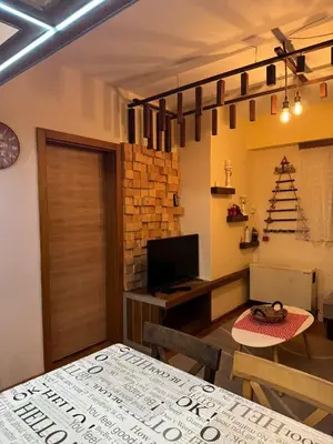 a living room with a table and a christmas tree at Suncani apartman 26 in Brzeće