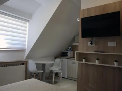 a room with a bed and a table and a tv at Peak Center Konaci in Kopaonik