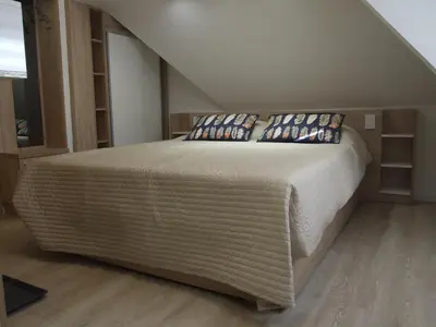 a bedroom with a large bed in a attic at Peak Center Konaci in Kopaonik