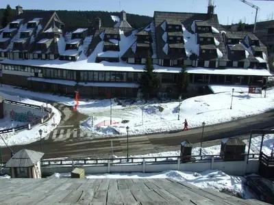 a ski resort with snow on the roofs of buildings at Peak Center Konaci in Kopaonik