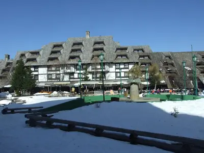 a large building with snow in front of it at Peak Center Konaci in Kopaonik