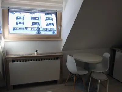 a small table and chairs in a room with a window at Peak Center Konaci in Kopaonik