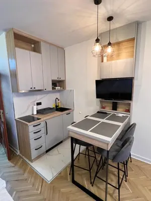 a small kitchen with a table and a stove at Apartmani Central & Free parking in Vrnjačka Banja