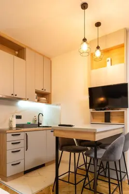 a kitchen with a table and chairs in a room at Apartmani Central & Free parking in Vrnjačka Banja