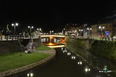 a bridge over a river at night with lights at Privatan smestaj knjazevac in Knjazevac.
