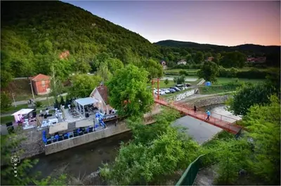 a bridge over a river next to a mountain at Privatan smestaj knjazevac in Knjazevac.