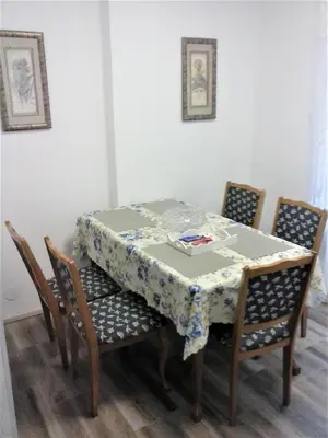 a table with chairs and a table cloth on it at Apartman Veljic in Niš
