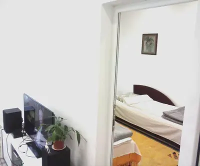a mirror in a room with a bedroom with a bed at Apartman Veljic in Niš