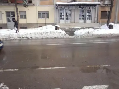 a person walking down a street with snow at Apartman Veljic in Niš