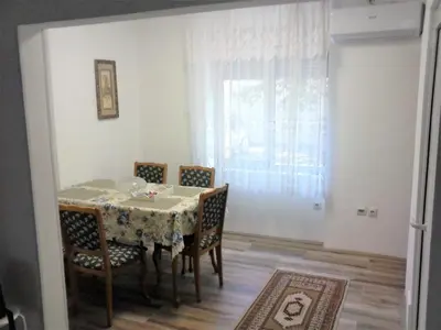 a dining room with a table and chairs and a window at Apartman Veljic in Niš