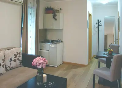 a living room with a couch and a table with flowers at Vila Ljubica in Vrnjačka Banja