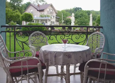 a table and chairs with a glass on a balcony at Vila Ljubica in Vrnjačka Banja