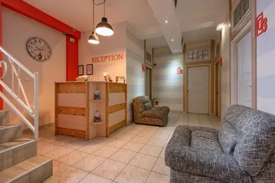 a waiting room with two chairs and a clock on the wall at B&B Bebinac in Leskovac