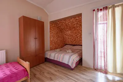 a bedroom with a bed and a cabinet and a window at B&B Bebinac in Leskovac