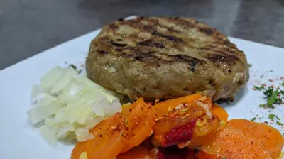 a plate of food with a piece of meat and vegetables at B&B Bebinac in Leskovac