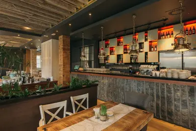 a dining room with a table and a bar at Hotel ABC in Leskovac