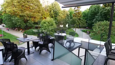 a balcony with tables and chairs and a garden at Hotel ABC in Leskovac