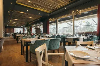 a dining room with tables and chairs and windows at Hotel ABC in Leskovac