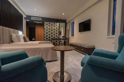 a hotel room with a bed and two chairs and a table at Hotel ABC in Leskovac