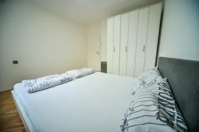 a large white bed in a room with white cabinets at goltepirot in Pirot