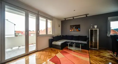 a living room with a couch and large windows at goltepirot in Pirot