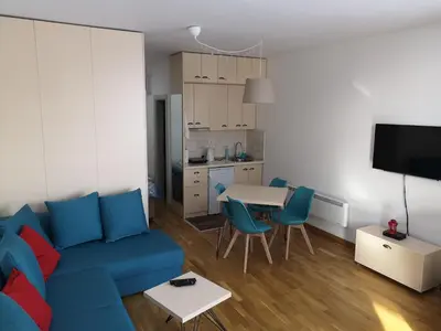a living room with a blue couch and a table at Apartman D11 Dvori in Kopaonik
